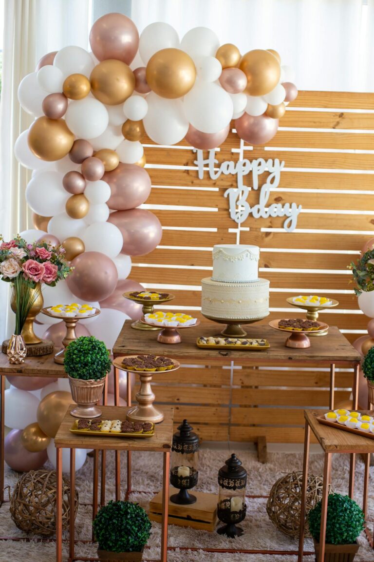 A beautifully decorated baby shower with balloons, dessert table, and cake.